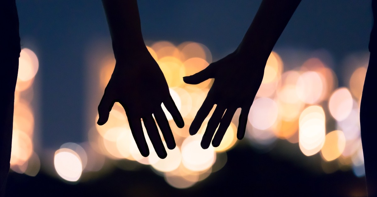 silhouette of hands reaching against city lights backdrop; How can I create healthy dating habits?