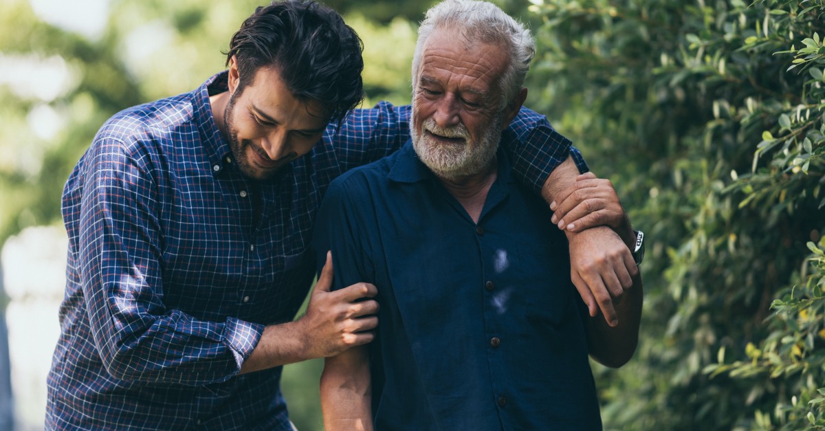 adult son with senior dad walking outdoors in park; prayers for dads on Father's Day