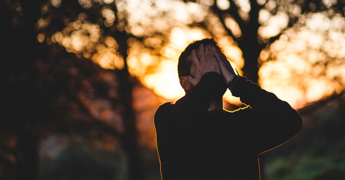 A stressed man covering his face; am I too hard on myself?