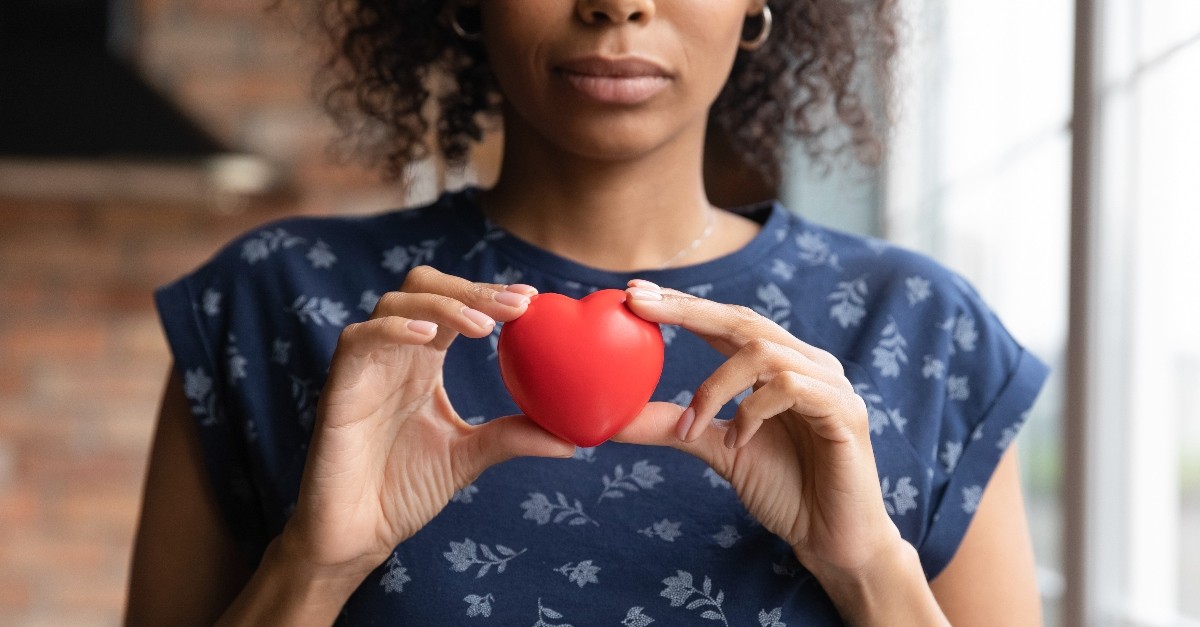 Woman solemnly holding a plush heart