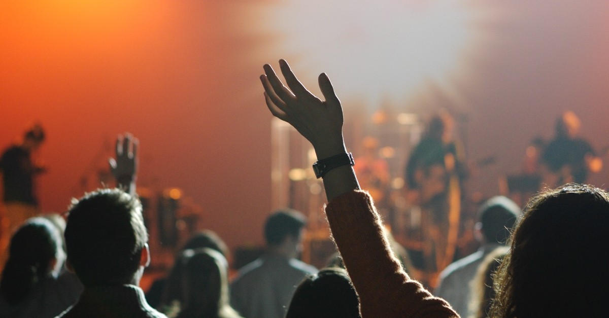 Woman with hand raised in worship