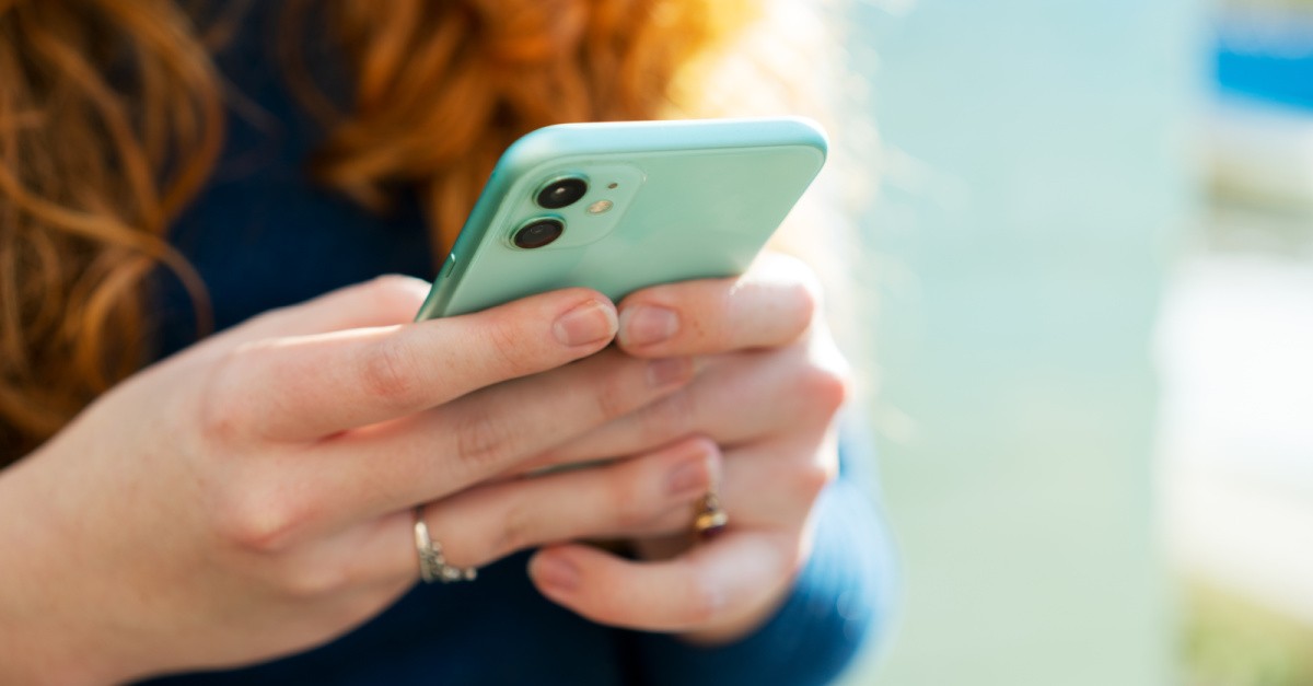 woman holding a phone; is ok to date online?