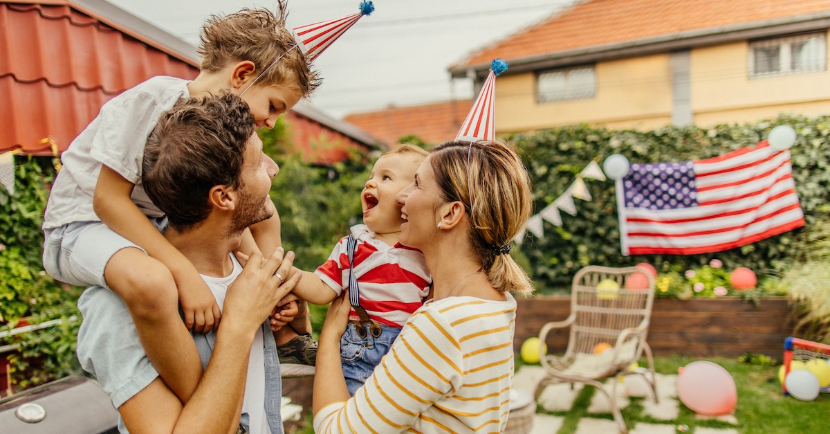 Happy family Fourth of July American flags patriotic cookout