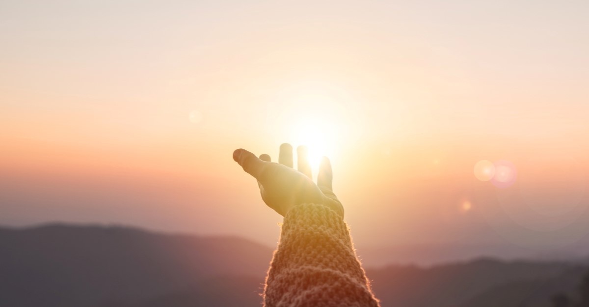 hand held out toward sunlight to illustrate blessed hope