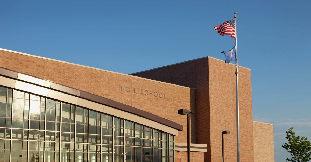 high school with flag to illustrate see you at the pole