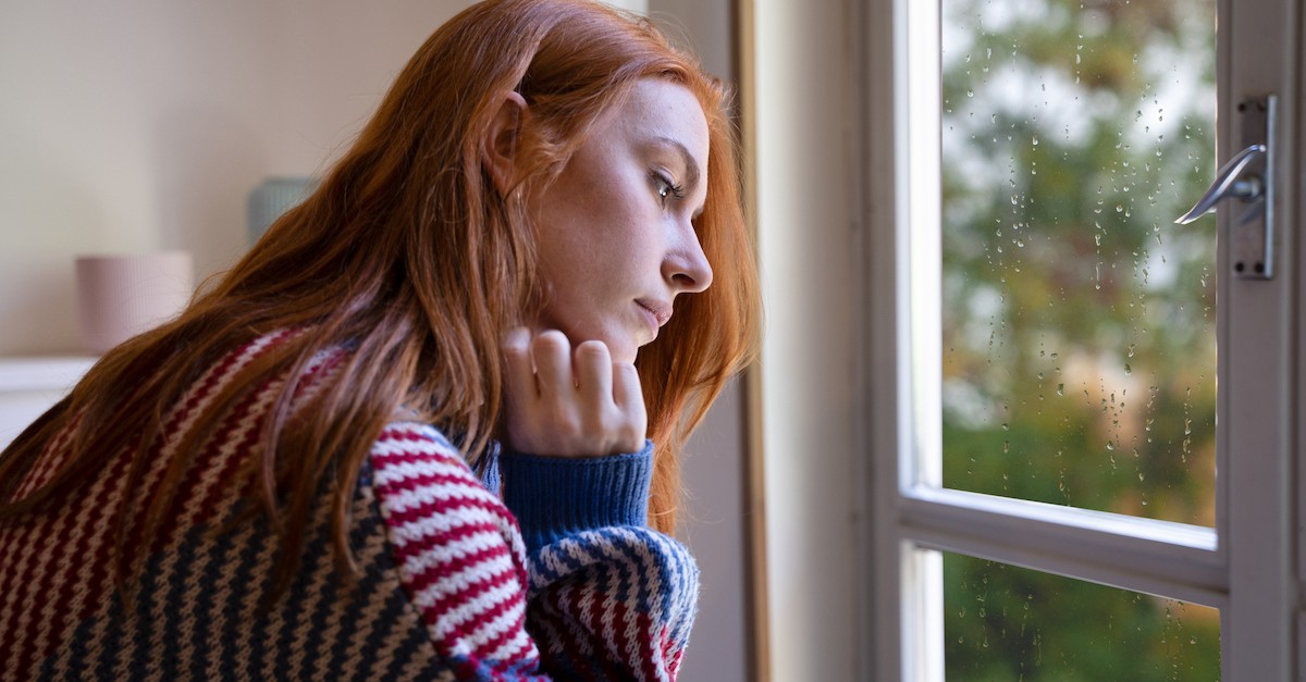 Depressed woman thinking sad at window fall